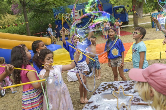 Eine Gruppe von Kindern zieht große Seifenblasen