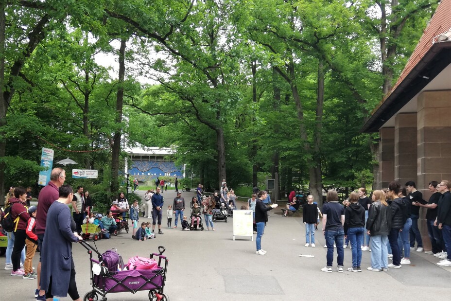 Tiergartenbesuchende und Chor am Wüstenhaus, Bild © Katharina Baatz / Musikschule Nürnberg