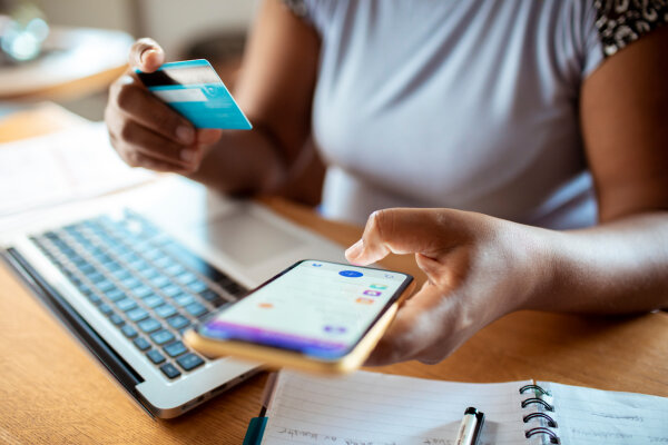 Close up woman using smartphone to transfer money from credit card