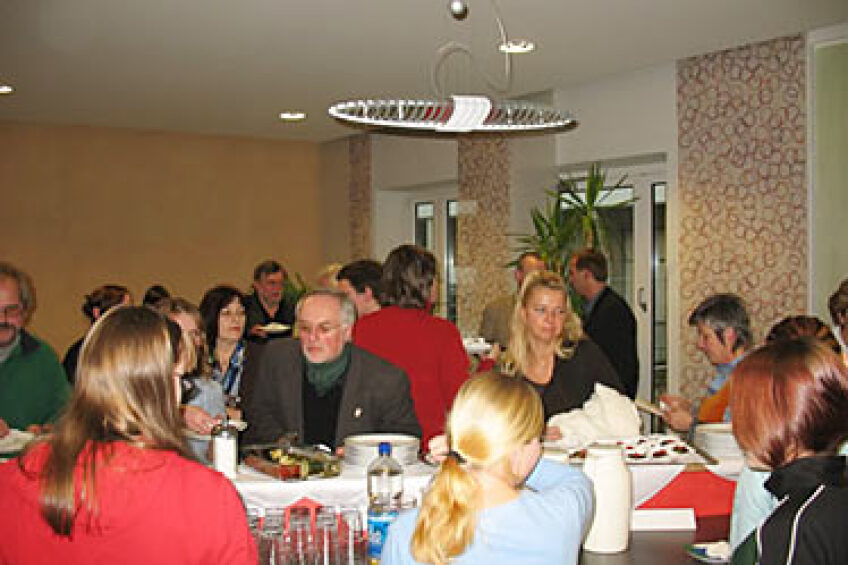 Teilnehmer am Tisch bei Gespräch und Essen, Bild © Bild: Pädagogisches Institut Nürnberg