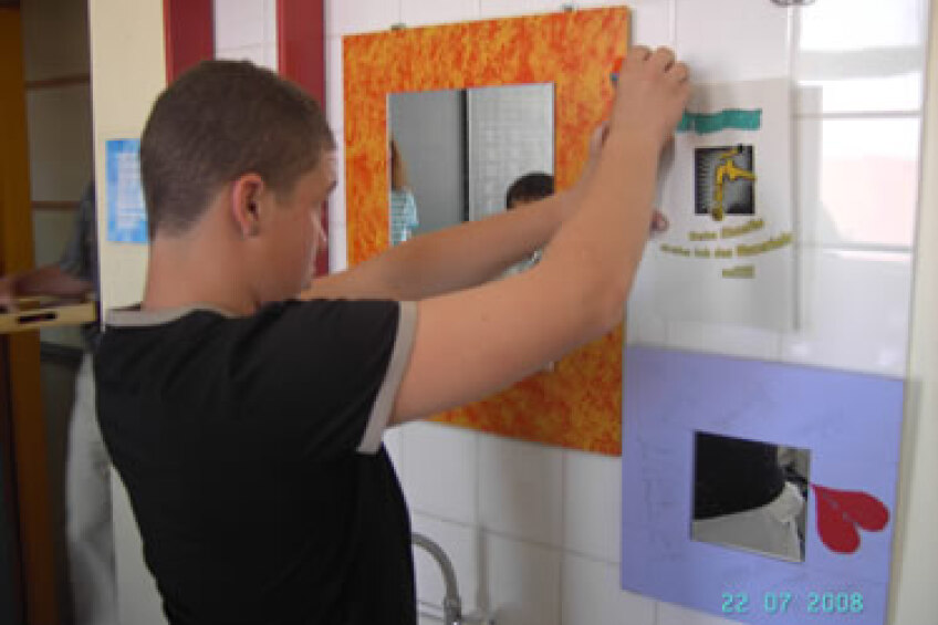 Schüler bringt ein Hinweisschild an, Bild © Bild: Pädagogisches Institut Nürnberg