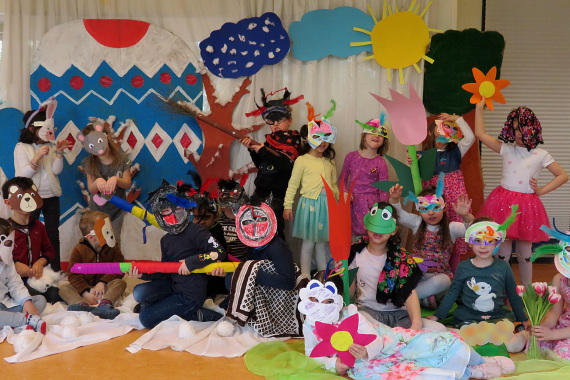 Kindergarten Kinder mit gebastellten Masken vertreigen den Winter