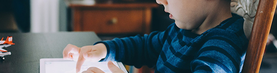 Ein kleines Kind sitzt am Tisch und spielt auf einem Tablet., Bild © pixabay.com