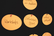 Auf einer Pinwand hängen mehrere ovale Kärtchen mit Text: Workshops, Inklusionssport, Sandburg-Wettbewerb, Brunch mit Nachbarn