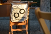 Ein Turnbeutel mit der Auschrift "Auf gute Machbarschaft" hängt auf einer Stuhllehne