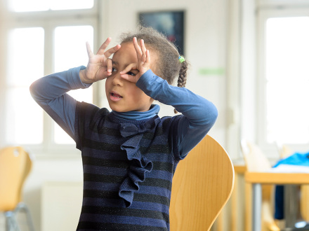 Foto von einem Mädchen. Das Mädchen schaut durch die Finger vor dem Gesicht., Bild © Uwe Niklas / Stadt Nürnberg