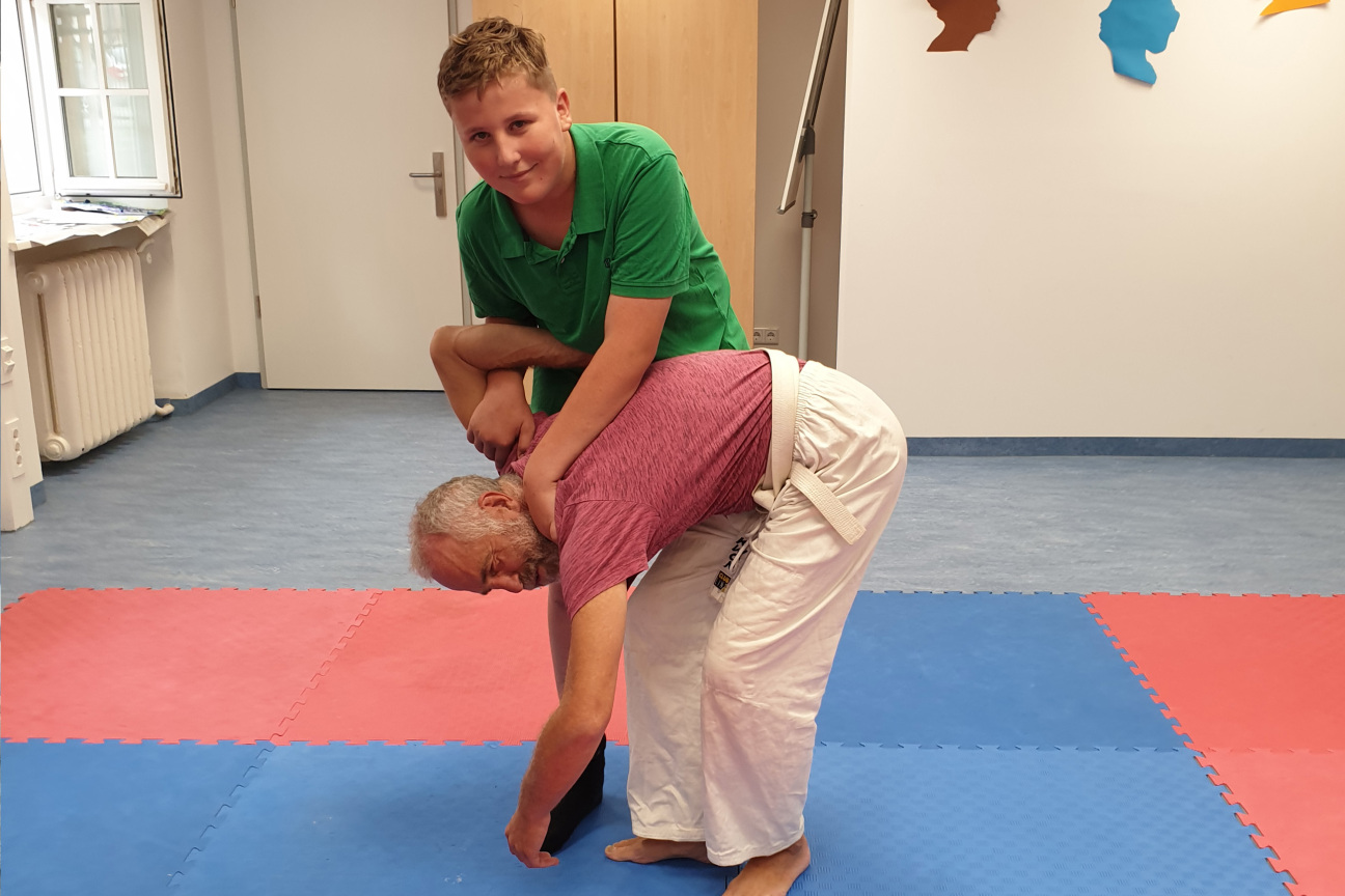 ein Junge und ein Mann trainieren Kampfsport