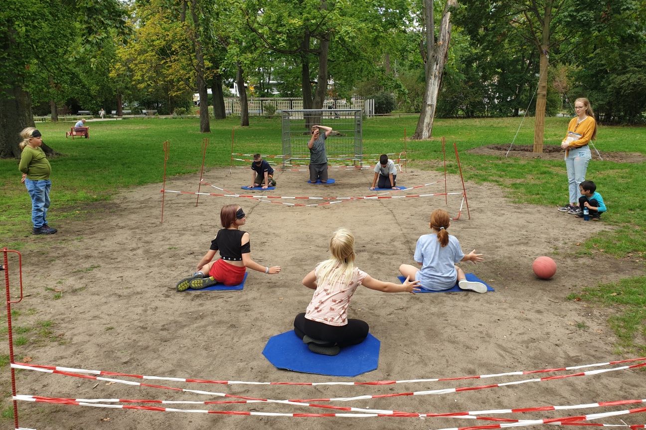 Kinder mit Augenbinden spielen Fußball