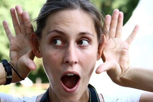 Eine Frau zeigt mit den Händen, dass sie hört