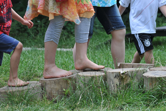 Vier Kinder laufen durch den Barfußpfad