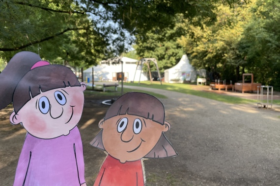 Zwei Zeichenmädchen aus Pappe vor dem Erfahrungsfeld