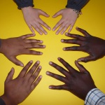 Drei Handpaare auf gelbem Untergrund