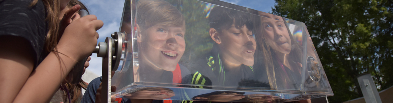 Bild © Stadt Nürnberg/Christine Dierenbach Drei Kinder schauen durch ein großes Prisma, Bild © Stadt Nürnberg/Christine Dierenbach