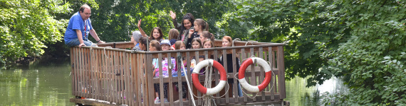 Kinder fahren mit der Fähre am Erfahrungsfeld über die Pegnitz