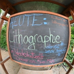 Kreidetafel mit dem Text: Heute Lithographie