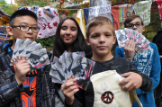 Vier Kinder zeigen Flyer zum Thema Ausbeutung