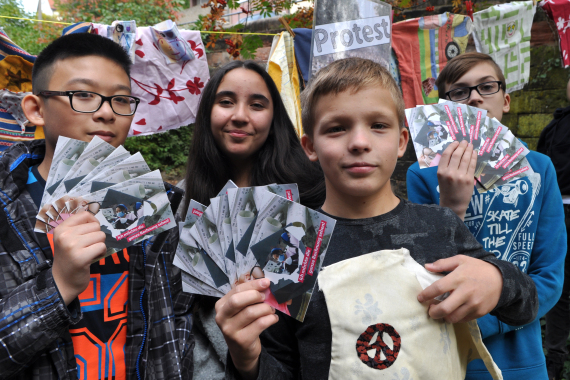 Vier Kinder zeigen Flyer zum Thema Ausbeutung