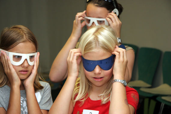 Kinder probieren Brillen aus, die verschiedene Sehbehinderungen simulieren
