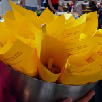 Ein Schüssel mit zusamengerollten gelbfarbigen Papierblätter