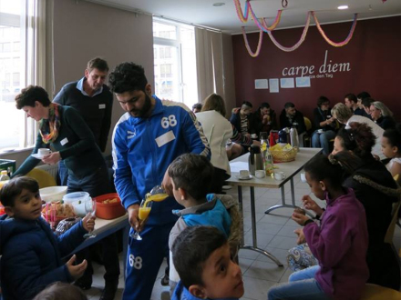 Foto von vielen Menschen zusammen in einem Raum. Die Menschen trinken zusammen Kaffee oder Orangen·saft und essen Snacks., Bild © Barbara Koch / Stadt Nürnberg