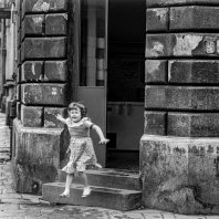 Ein kleines Mädchen hüpft die Treppen eines Hauses runter