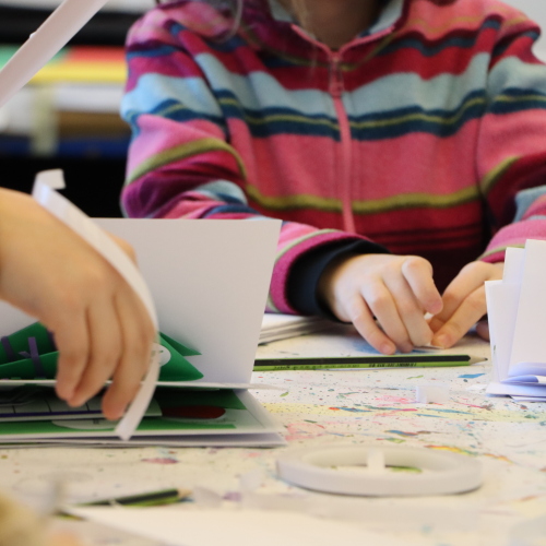 Kinder falten Hefte aus Papier