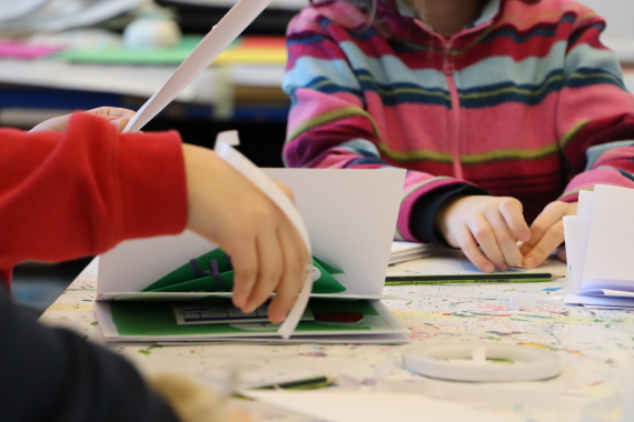 Kinder falten Hefte aus Papier