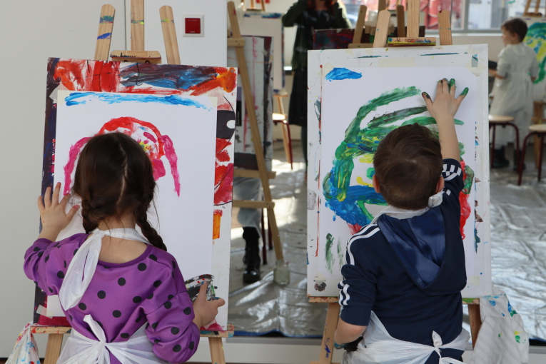 Zwei Kinder malen mit Fingermalfarben