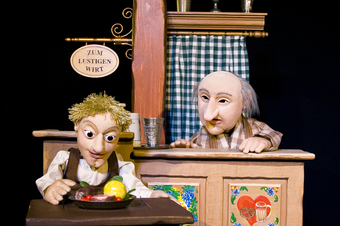 Zwei Figuren. Eine vor dem Magischen Tisch aus dem Märchen