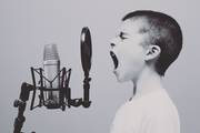 Junge gibt ein lautes Schrei ins Microphone