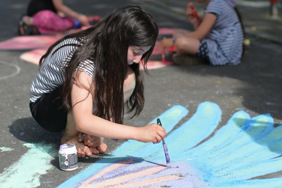 Mädchen malen auf der Straße mit Kreidefarben