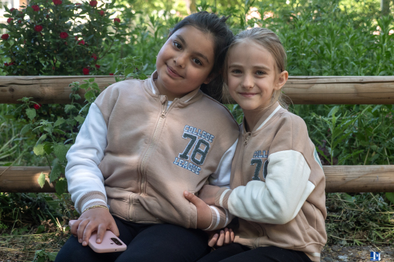 Zwei Mädchen schauen lächelnd in die Kamera