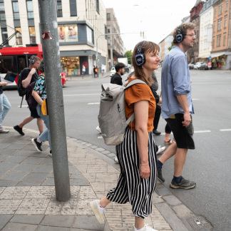 ( Bild: Oleksandra Shyshlakova / Stadt Nürnberg ) Mehrere Personen mit Kopfhörern laufen durch die Straße