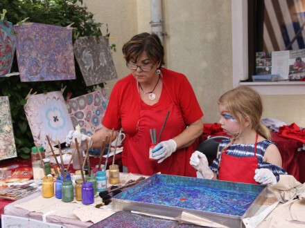 Foto von einer Frau und einem Mädchen. Die Frau hilft dem Mädchen beim Malen von einem Bild., Bild © Kulturladen Loni-Übler-Haus/Stadt Nürnberg