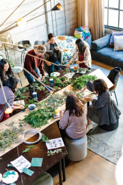Frauen basteln mit grünen Pflanzen an einem Tisch