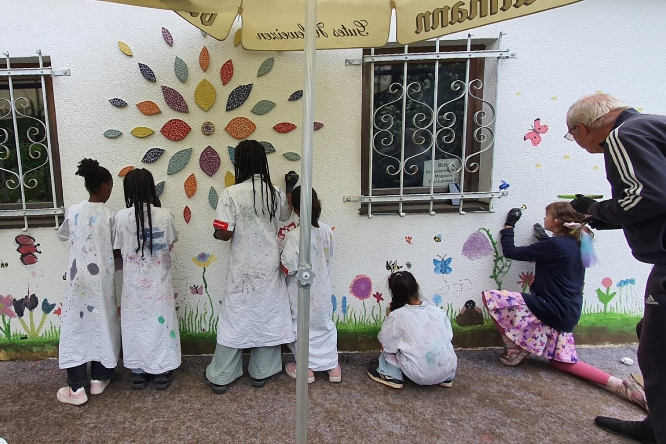 Kinder und ältere Erwachsene gestalten mit Malerei und Mosaik eine Verkaufshütte neu., Bild © Sonja Wolfstaedter / Stadt Nürnberg