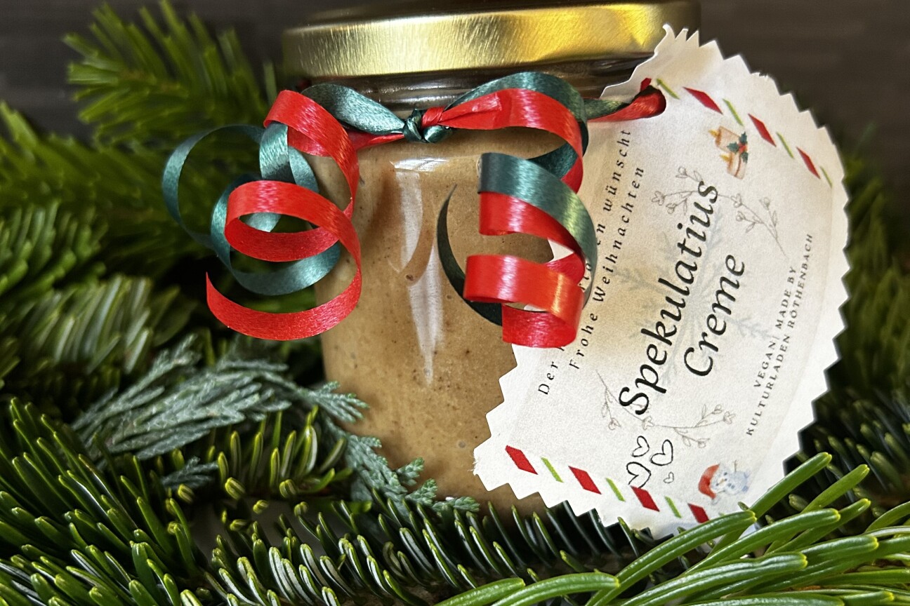 Ein weihnachtlich verziertes Einmachglas steht auf Tannenzweigen.