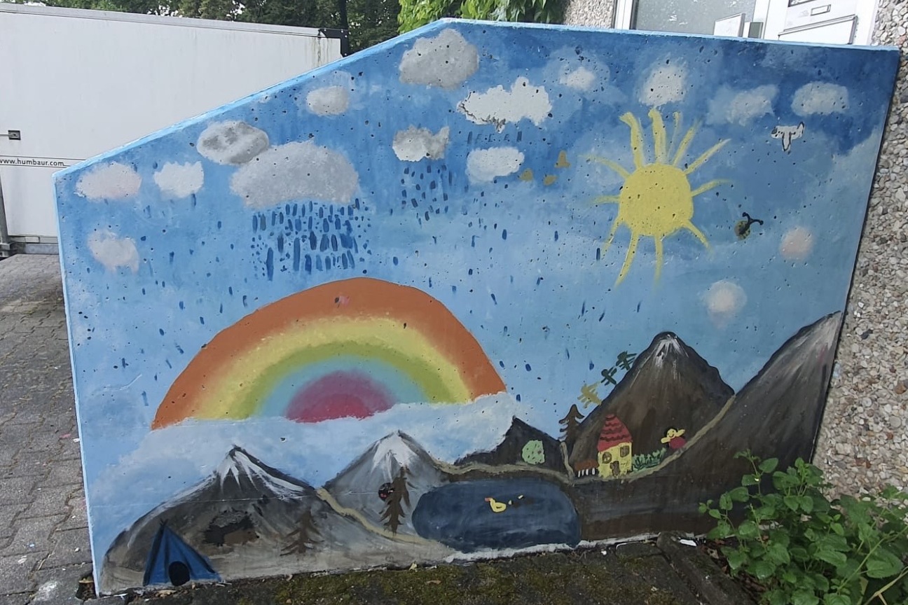 Ein bunt gestalteter Treppenaufgang/Geländer mit Regenbogen und Bergkulisse, Bild © Sonja Wolfstaedter / Stadt Nürnberg