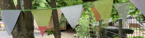 Eine Winpelkette an einem Baum in einem Vorgarten