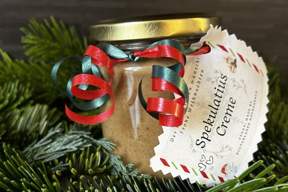 Ein weihnachtlich verziertes Einmachglas steht auf Tannenzweigen.