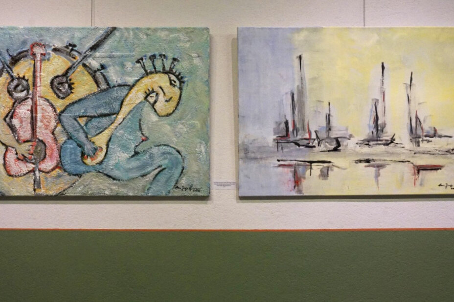 Es sind zwei Werke des Künstlers zusehen, welche an einer Wand aufgehängt sind. Die Wand ist weiß und die untere Hälfte ist grün. Bei den Gemälden handelt es sich um abstrakte Kunst. Es wurden gelbe, grüne, graue und rote Farbtöne verwendet., Bild © Sonja Wolfstädter / Stadt Nürnberg