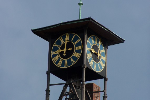 Turmuhr mit goldenem Ziffernblatt auf blauem Grund