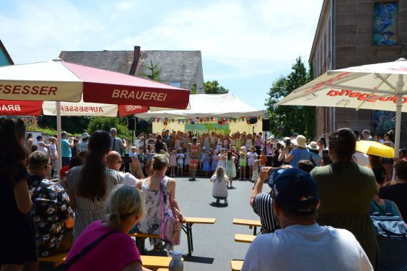 Sonnenschirme, Bierbänke ein Bühnezelt mit singenden Kindern und ganz viel Publikum