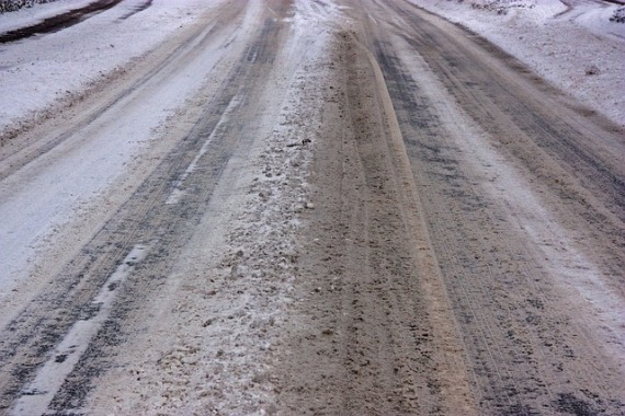 Eine verschneite Straße mit Reifenspuren