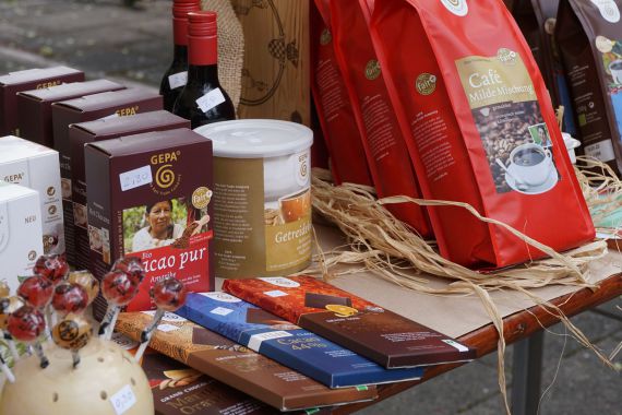 Auf einem Tisch stehen Kaffeetüten, Schokoladenpackungen und andere nachhaltige Produkte