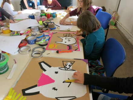 foto von Kindern beim Basteln. Die Kinder sitzen an einem langen Tisch., Bild © Kula Almoshof