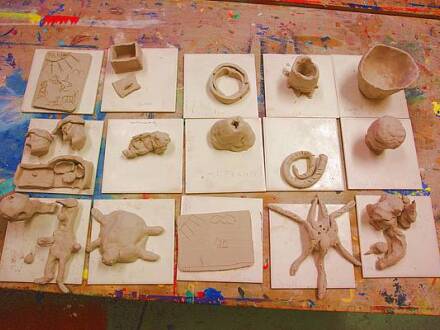 Foto von 15 kleineren Dinge aus Ton. Die Dinge liegen auf weißen Fliesen zum Trocknen auf einem Tisch., Bild © Vischers Kulturladen / Stadt Nürnberg