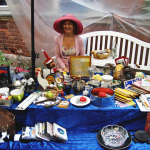 Lächelnde Frau verkauft Sachen am Flohmarkt