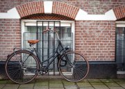 Ein Fahrrad, dass an einer Hauswand aus Ziegeln steht