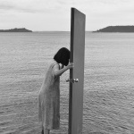 Frau mit Tür im Meer stehend